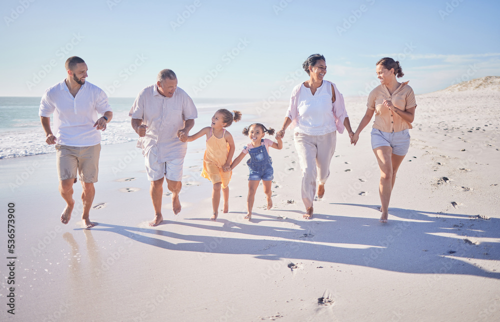 Happy, children and family running on beach together while parents and grandparents smile or follow. Carefree kids having fun during summer beach vacation in California with happiness, love and laugh
