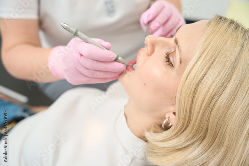 Doctor in gloves treats a patient's tooth