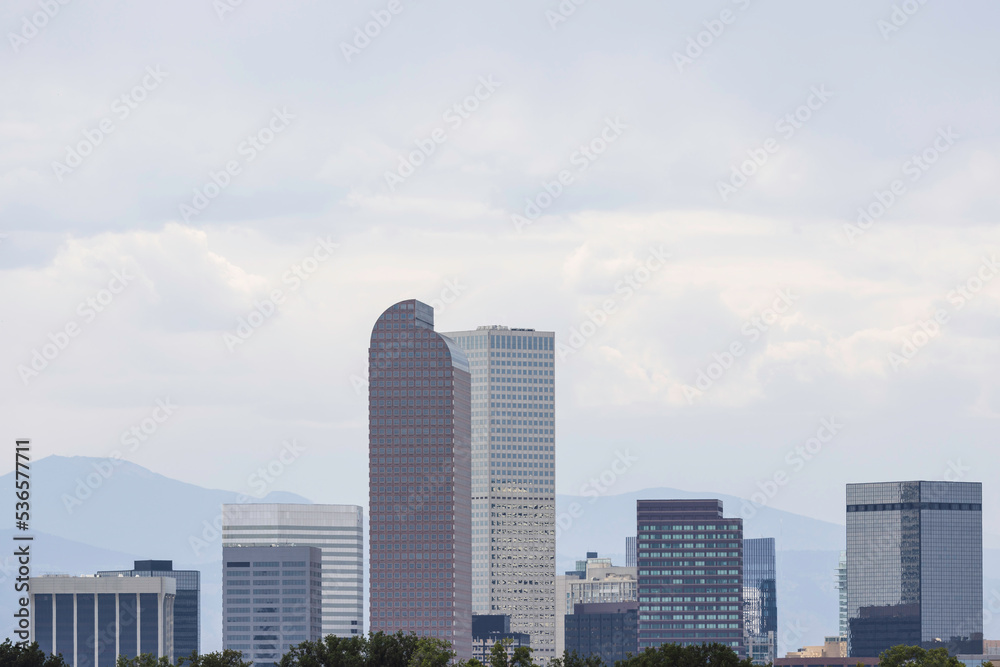 Fototapeta premium Denver skyline with mountains behind during daytime with copy space