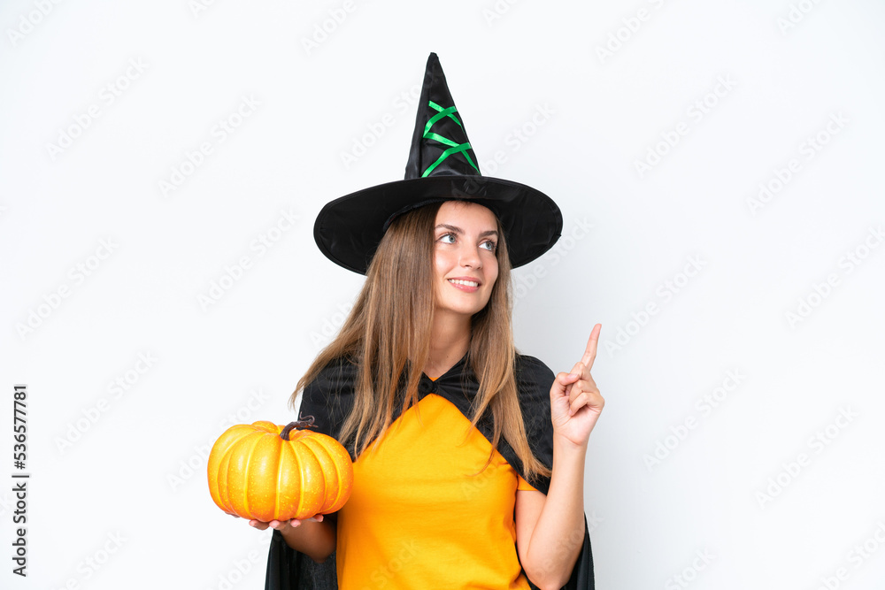 Young caucasian woman costume as witch holding a pumpkin isolated on white background pointing up a great idea