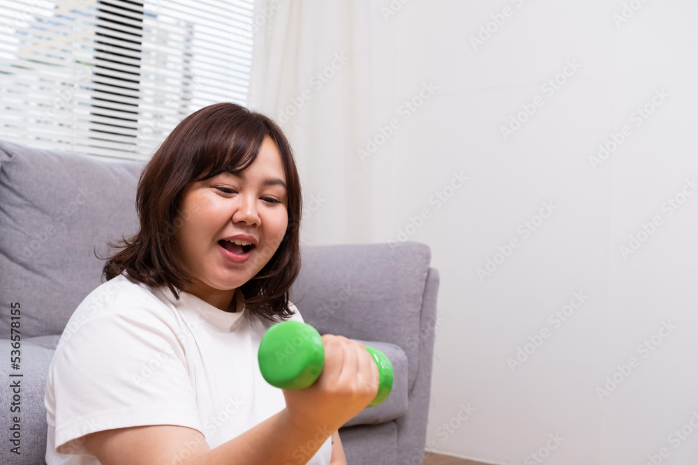 Young Asian chubby woman hold dumbbell for exercise and weight training. Fighting while diet during weight loss program with positive emotion. Portrait shot on white background. Young Asian chubby woman hold dumbbell for exercise and weight training. Fighting while diet during weight loss program with positive emotion. Portrait shot on white background.