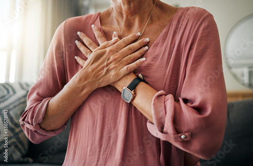 Senior woman, hands or chest pain in heart attack, anxiety or panic in house or home living room. Zoom, stroke or cardiovascular emergency for sick retirement elderly or stress person in medical risk