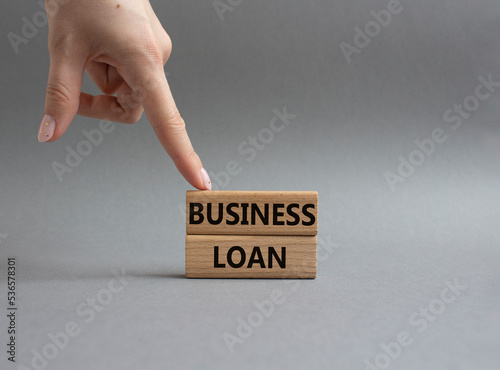 Business loan symbol. Concept words business loan on wooden blocks. Beautiful grey background. Businessman hand. Business and business loan concept. Copy space.