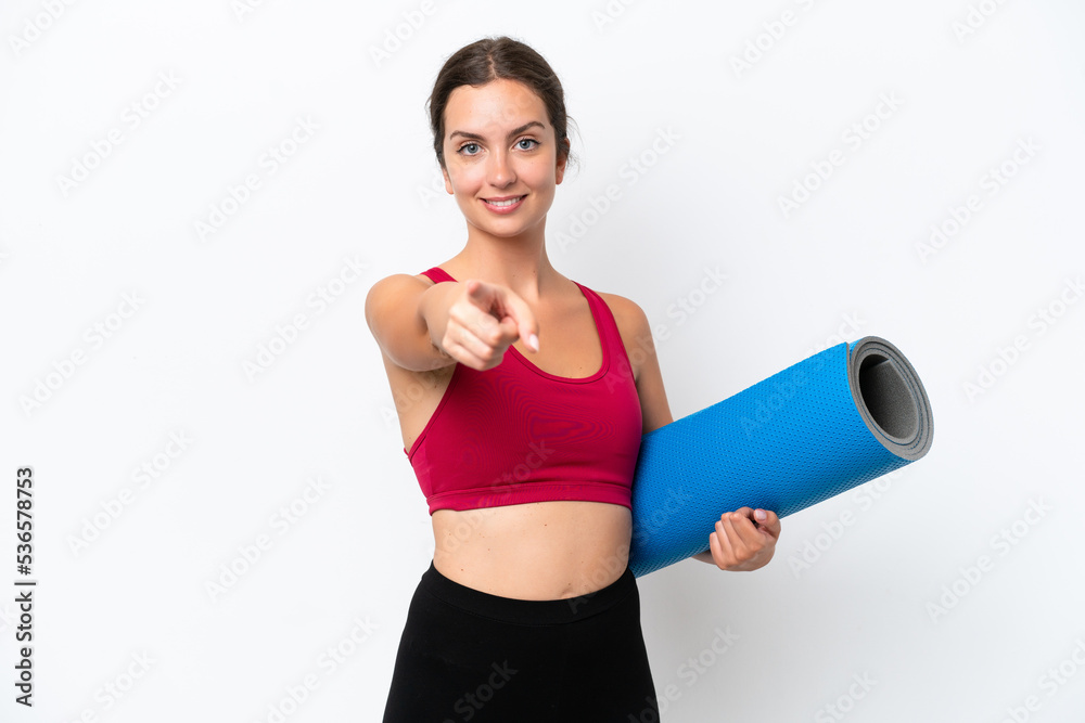 Young sport caucasian woman going to yoga classes while holding a mat isolated on white background pointing front with happy expression Young sport caucasian woman going to yoga classes while holding a mat isolated on white background pointing front with happy expression