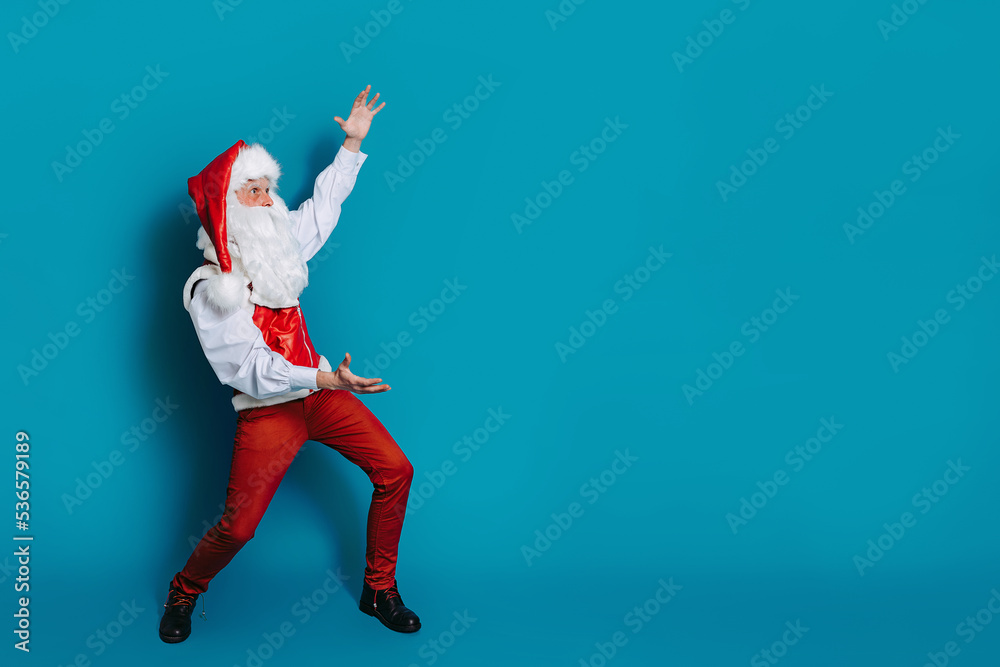 Full size photo of cool santa claus who gesturing hands pointing to ad text. New Year advertisement 