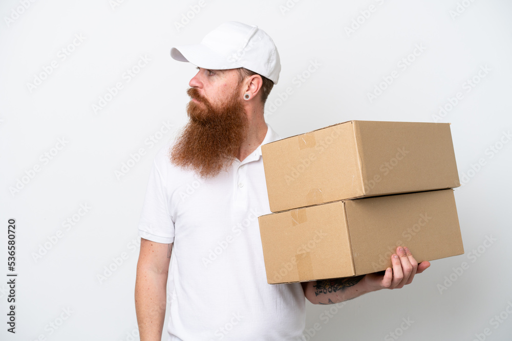Delivery reddish man isolated on white background looking to the side
