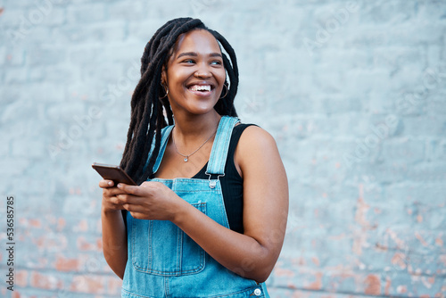 Smartphone, digital networking and black woman with mobile app, social media post or 5g internet outdoor with mock up blue wall. Happy african gen z girl typing on her cellphone for youth online blog