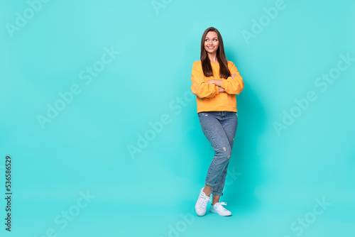 Full size photo of pretty nice lady with folded arms looking empty space isolated over cyan color background