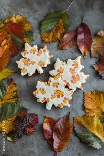 Gingerbread in glaze with edible print. Cookies in the form of maple leaves. Unusual sweets for the autumn holiday.