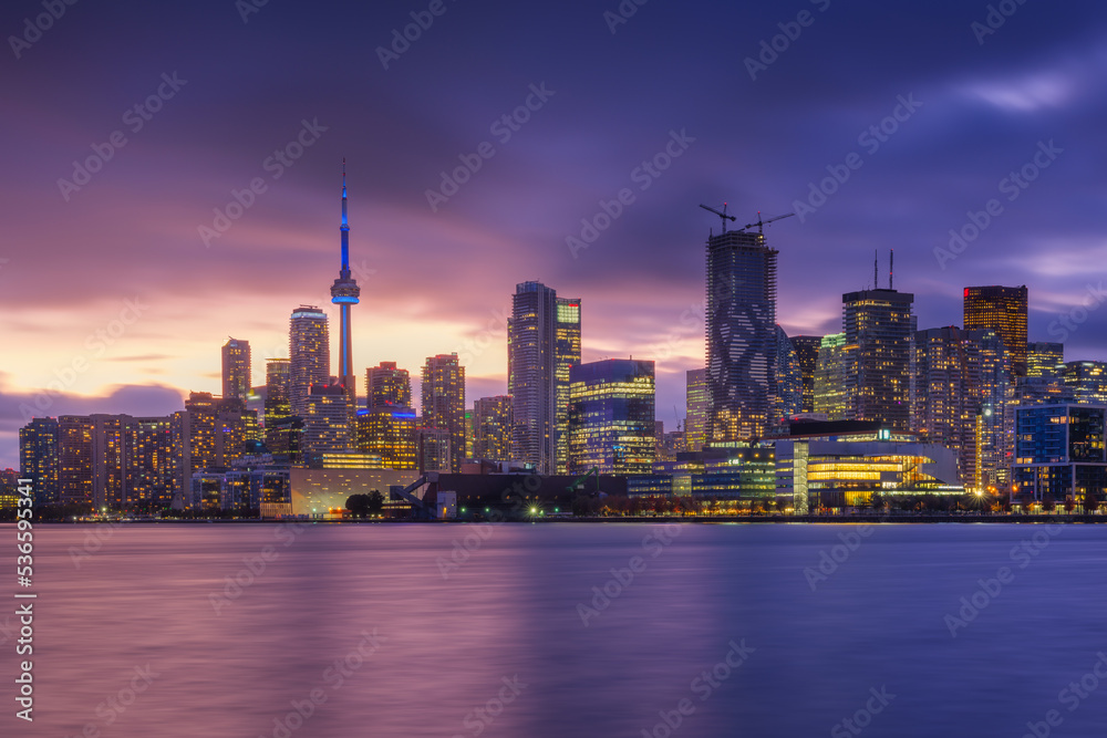 Obraz premium Toronto, Canada. View of the skyscrapers and the CH tower. View of Downtown in the evening. Nighttime illumination of the city. The city at the shore of the lake. Cityscape during sunset.