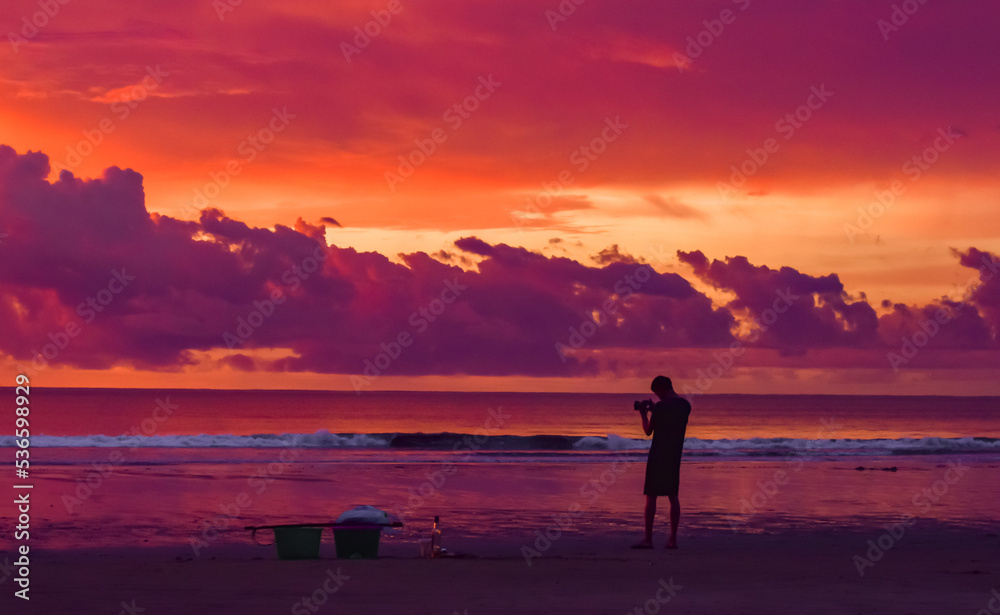 Silhouette image of camera man taking photo at Chaung Tha beach, Myanmar. Photoshooting at sunset.