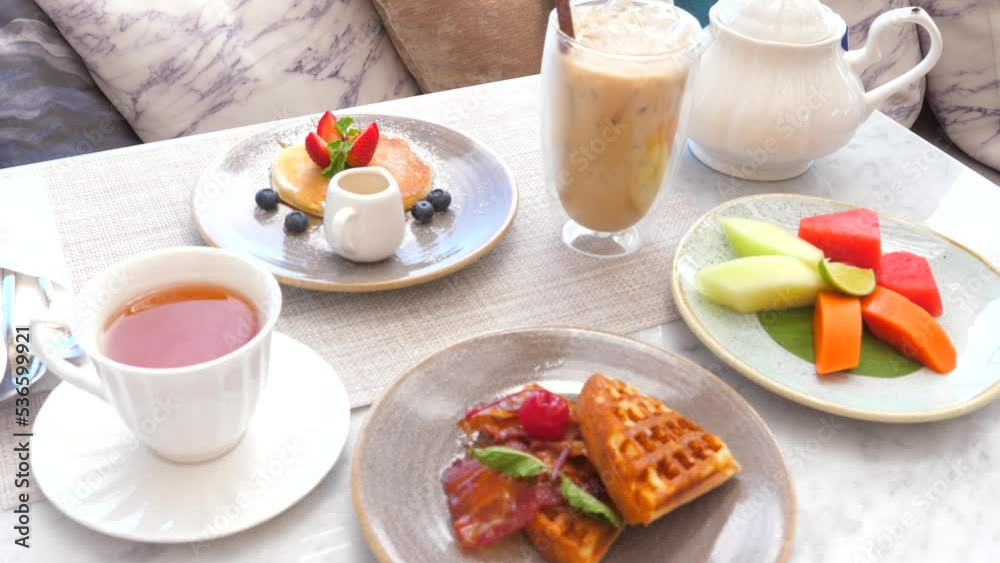 Breakfast in hotel with pancake and belgian waffles in outdoors cafe Breakfast in hotel with pancake and belgian waffles in outdoors cafe