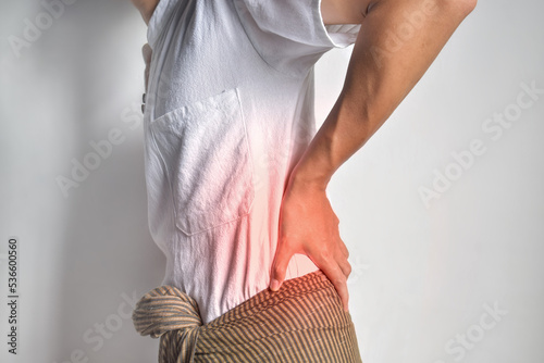 Asian man suffering from back and loin pain. It can be caused by renal stone. photo