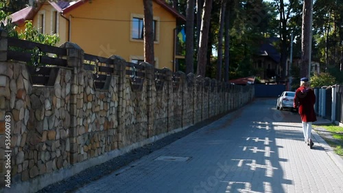 Wallpaper Mural Back view of young woman in blue hat riding electric scooter across sunny street enjoying beautiful day outside. Eco friendly transport. Modern urban freelance lifestyle. Future generation concept. Torontodigital.ca