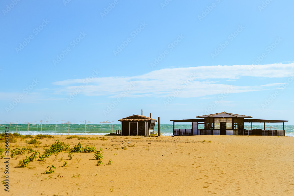 Empty beach in autumn season. Beach cafe on the deserted sunny sandy coast of the Black Sea. Empty beach in autumn season. Beach cafe on the deserted sunny sandy coast of the Black Sea.