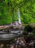 the view of a waterfall in the beautiful tropical forest