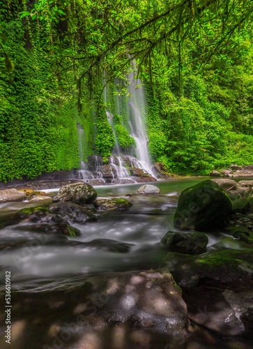 the view of a waterfall in the beautiful tropical forest