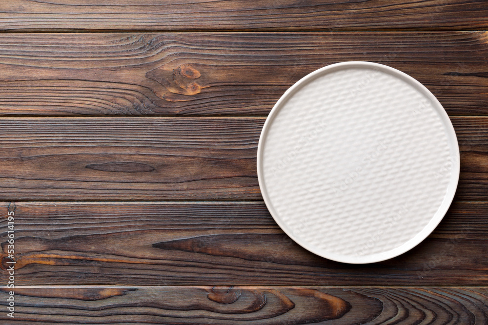 Top view of empty light plate on wooden background. Empty space for your design Top view of empty light plate on wooden background. Empty space for your design