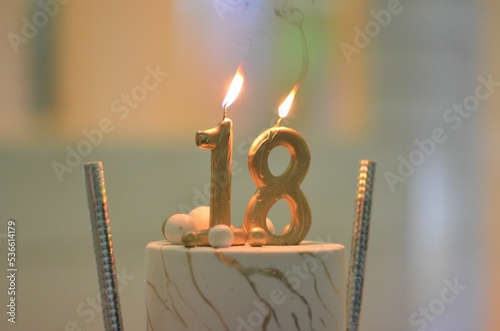 Closeup of a birthday cake with burning candles. 18th anniversary. photo