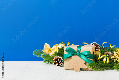 New Year Christmas mood, gift box, branches of a christmas tree, New Year decorations on a colored background