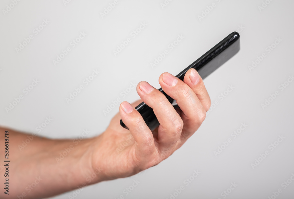Hand holding mobile phone, abstract smartphone, side view Hand holding mobile phone, abstract smartphone, side view