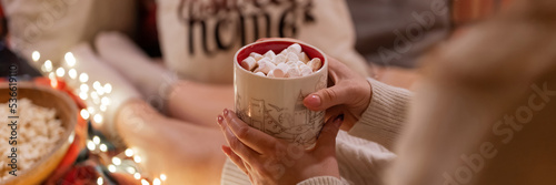 Quadro em tela cup of hot chocolate or coffee drink with marshmallows in female holding hands of woman in knitted sweater relaxing and enjoyment the holidays in bed home on christmas or new year holidays eve