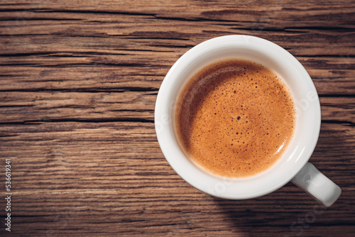 Small cup of espresso coffee crema on wood