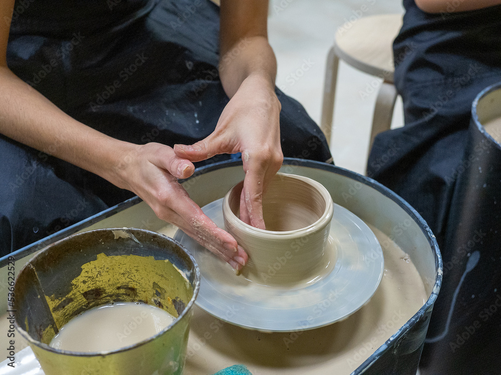 A close-up of a craftsman making an object out of clay on a potter's wheel. Handmade, hobby, hobby, selective focus A close-up of a craftsman making an object out of clay on a potter's wheel. Handmade, hobby, hobby, selective focus