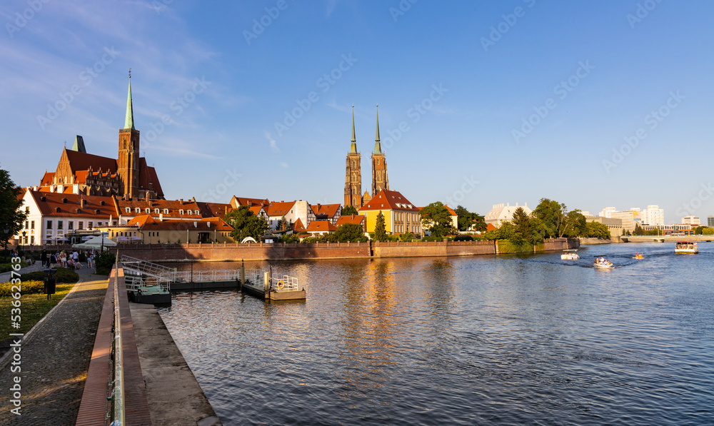 Naklejka premium Panoramic view of Ostrow Tumski Island with Holy Cross collegiate and St. John Baptist gothic cathedral over Odra river in historic old town quarter of Wroclaw in Poland