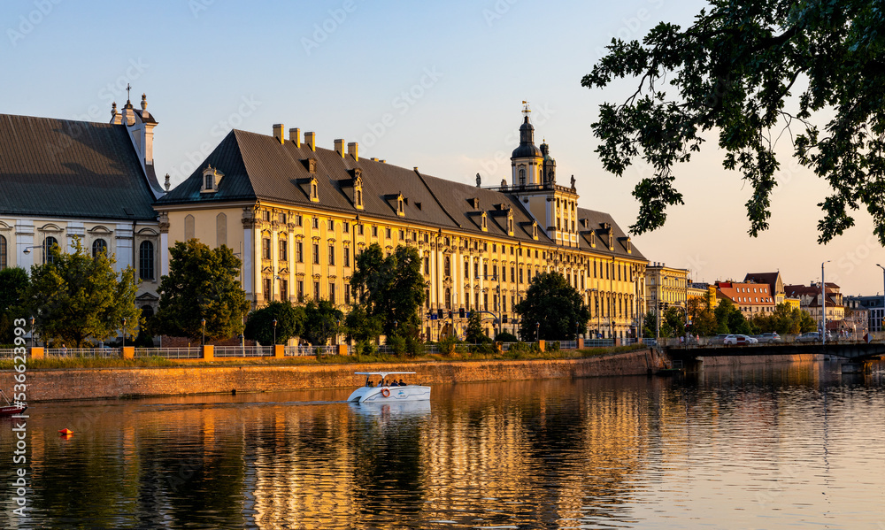 Fototapeta premium Historic old town quarter with Wroclaw University and Grodzka street embankment at sunset over Warta River in Wroclaw in Poland