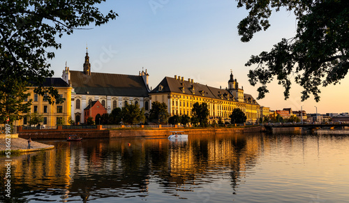 Historic old town quarter with Wroclaw University and Grodzka street embankment at sunset over Warta River in Wroclaw in Poland
