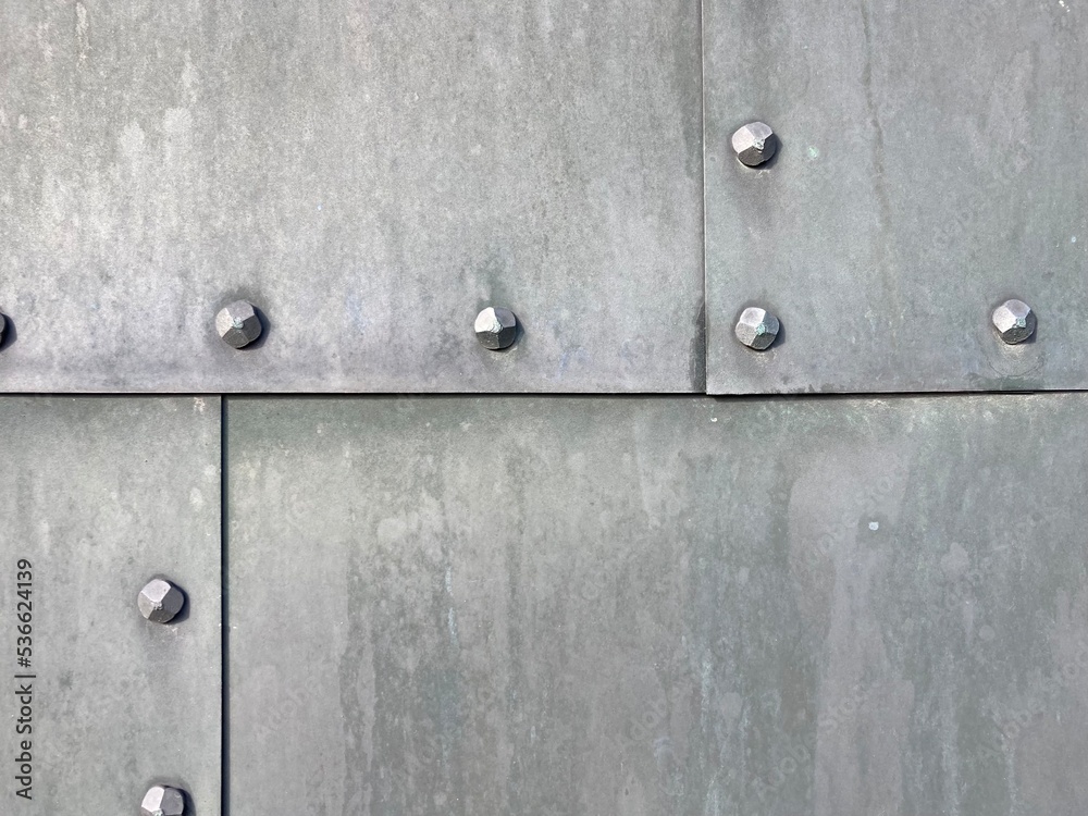gray metal plates fastened together with rows of rivets