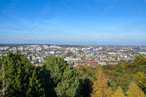View of the modern part of Lviv over the crowns of autumn trees on a sunny day. Ukraine