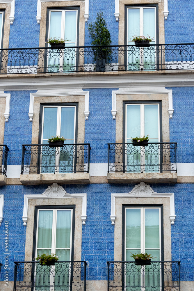 Historic building in Lisbon with facade decorated with classic blue tiles (azulejo) and balconies