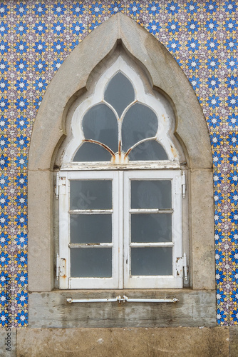 Detail of rustic moorish window in Sintra, with colorful Portuguese tiles facade (azulejo)