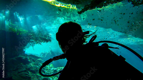 Silhouette of woman scuba diving in chac-mool cenote near cancun mexico photo