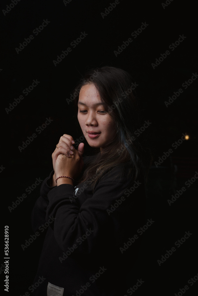 Asian young woman who wants to express something with expression. Asian female model wearing black t-shirt on bokeh background.