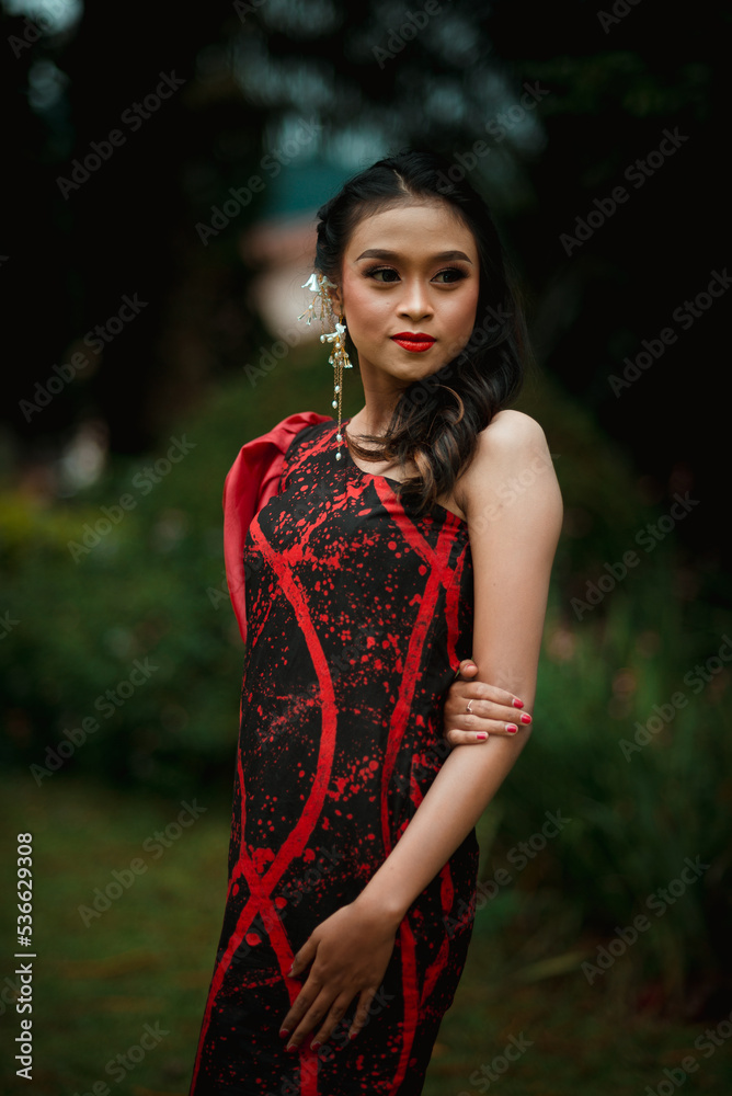 Stylish young Asian woman posing in traditional dress. Asian female model taking pictures outdoors with bokeh or blurred background. Stylish young Asian woman posing in traditional dress. Asian female model taking pictures outdoors with bokeh or blurred background.