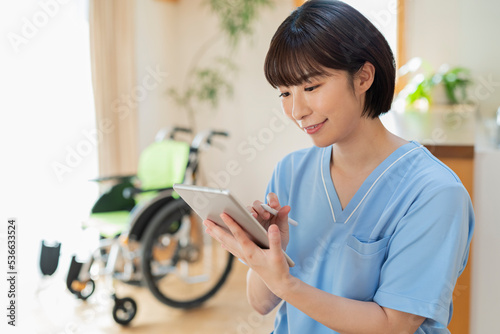 Plakat タブレットで日誌を書く女性医療従事者
