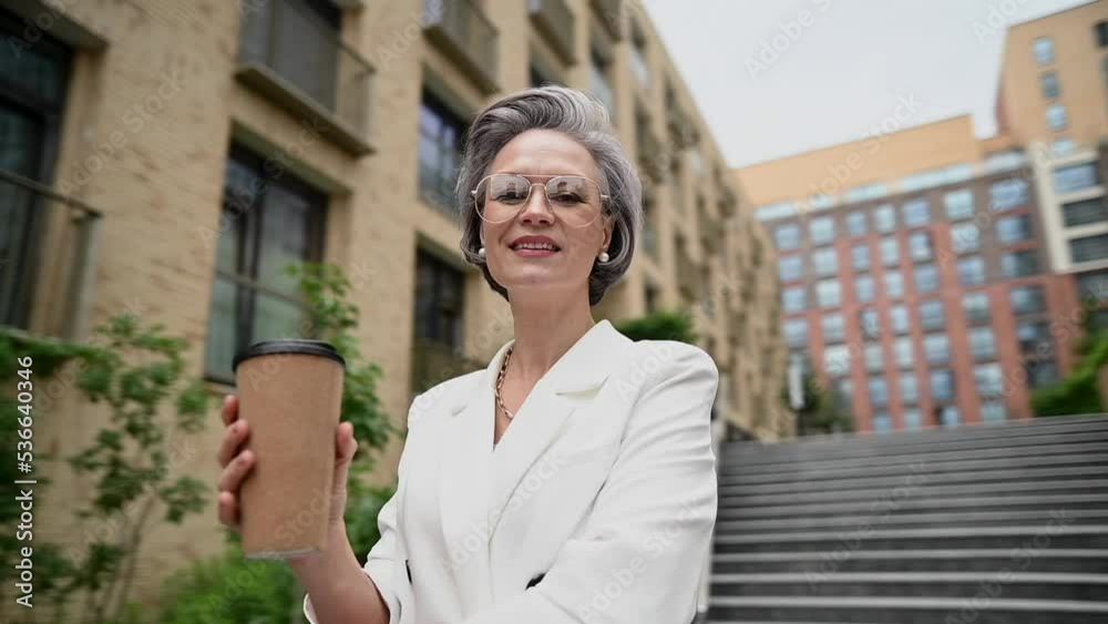 Beautiful caucasian elderly gray-haired business woman drinking coffee outdoors. Video 360 degrees. Beautiful caucasian elderly gray-haired business woman drinking coffee outdoors. Video 360 degrees.