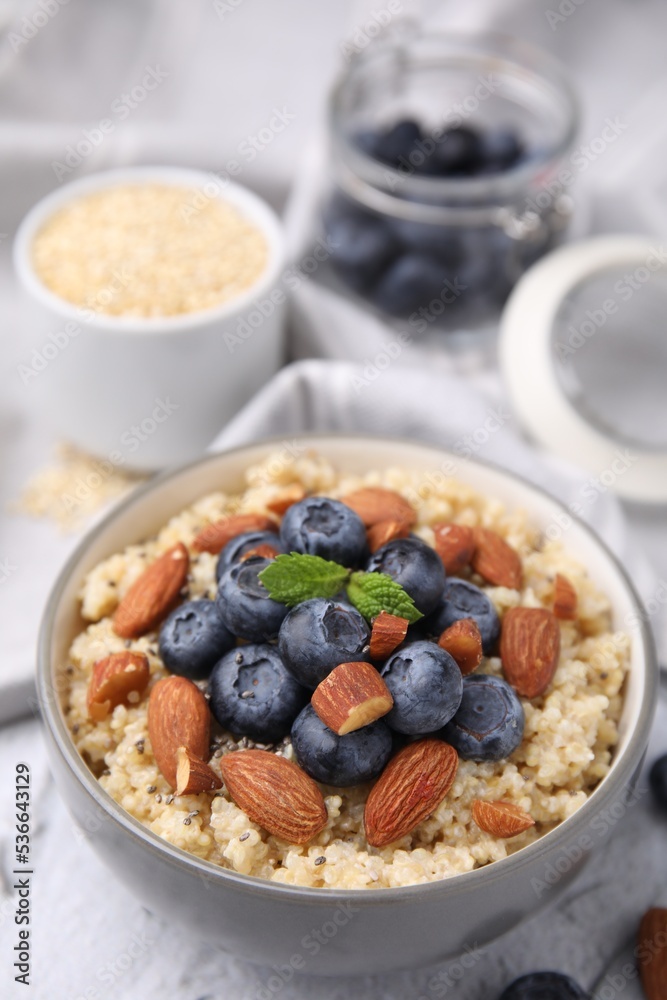 Bowl of delicious cooked quinoa with almonds and blueberries on white textured table, closeup Bowl of delicious cooked quinoa with almonds and blueberries on white textured table, closeup