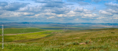 Bald Mountain in the Buryat Republic of Russia. Green hills against a blue sky with clouds.