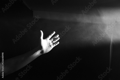 mãos em direção a luz de uma janela  photo
