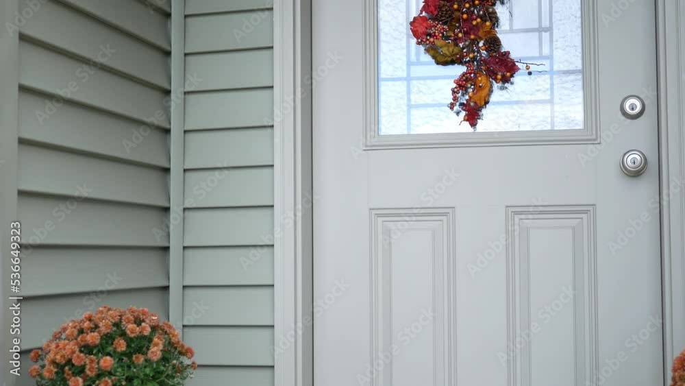 A front door of a modern home with pumpkin on porch