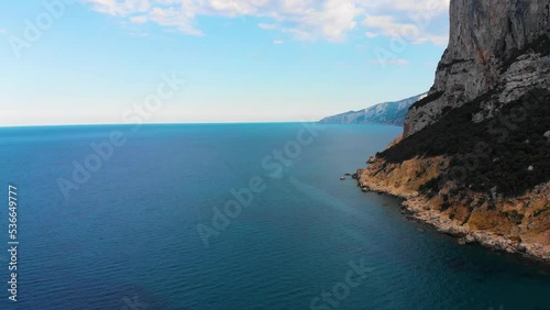 Drohne im Überflug über ein Kliff und Strand am Meer bei schönem sonnigen Wetter und ruhiger See 4k