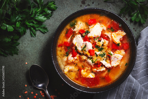 Warming autumn soup with red lentils, chicken fillet, vegetables, spices and paprika, comfort food. Green table, top view photo