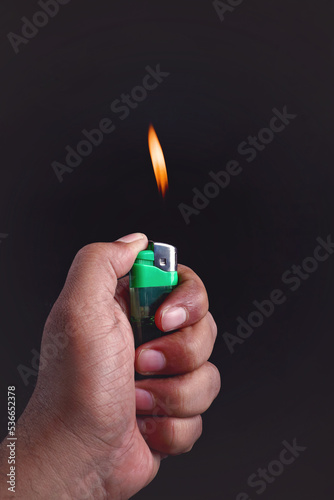 Hand holding fire lighter isolated on black background. 