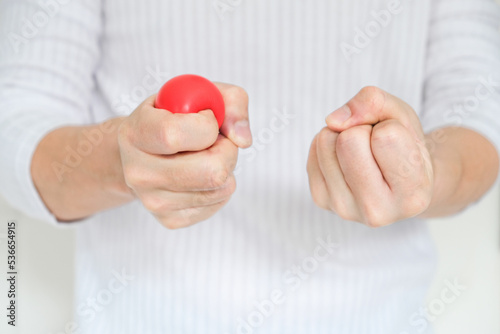 Hands of man with a gentle personality He exhibits stressful behavior from work, and he squeezes the yellow ball expressing emotion, anger, displeasure. Medical concepts and emotional regulation