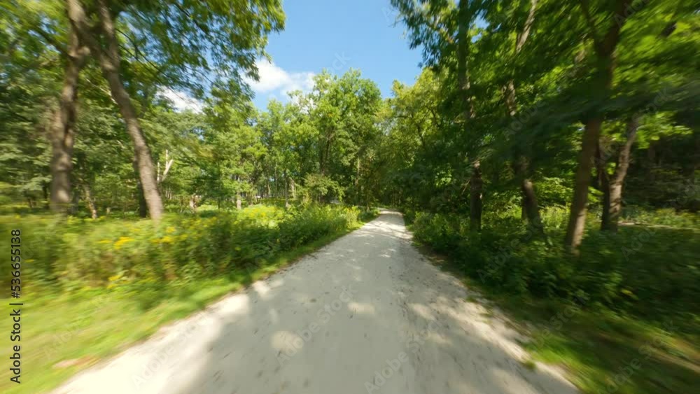 Biking and running on crushed limestone trail path. Going fast and downhill on gravel with many curves. First person view POV cycling ride and run. Forest preserve tree canopy Glen Waterfall Preserve Biking and running on crushed limestone trail path. Going fast and downhill on gravel with many curves. First person view POV cycling ride and run. Forest preserve tree canopy Glen Waterfall Preserve