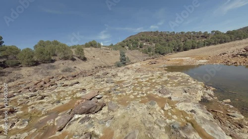 Dynamic FPV drone POV flight up rocky dry riverbed in southern Spain photo